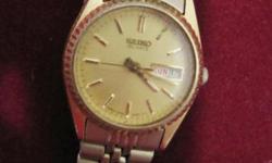 woman's Seiko watch with gold face, has date, needs battery, quartz movement, is water-resistant, some minor scratching on crystal