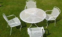 This vintage patio set consists of a wrought iron table and 4 chairs. The table is about 42" in diameter, 28" tall, and the chairs are about 33" tall in the back, 16" high to the seats, 22" wide from arm to arm, and the seats are about 20" wide x 18 1/4"
