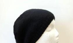 A hand knitted warm black beanie beret. Worn by men and women.Made with acrylic yarn. Medium size. Worn by men or women. Very stretchy, will fit any head, stretches out to 31 inches around. Completely hand knitted. The measurements are lying flat on a