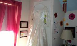 Size 12 wedding dress w/veil for sale. Imported cadlelight ivory Italian satin with an off-the -shoulder scalloped neckline and long, tapered sleeves. The ballgown skirt was adorned with lace appliques and bead trim, with a cathedral-length train.