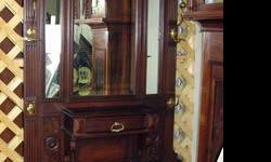 This an undated Hall Tree that appears hand made or made by a low-volume manufacturer. A very beautiful piece with handsome brass hooks and rails along with beveled mirrors. This also has a center draw for keys and such as well as a base planter with