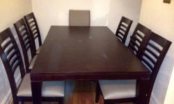 Solid wood dining room table 64" long with 2 leaves of 20", making it extendible to 84" and 104" with 42" width. Eight black leather chairs. Everything in excellent condition.
