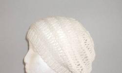 This open weave wool beanie it is knitted with 100% wool yarn. The color is a soft winter white. The open weave pattern is 6 rows of a long lacy stitch. The measurements are 9 inches across the brim. The width (lying flat on a table) 11 inches and the
