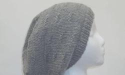 The color of this wool oversized slouchy is a medium gray. It is made with a soft pure wool yarn. Medium thickness, very stretchy, will fit any head, will stretch out to 31 inches around. This pattern is called ?tracks?. The measurements are lying flat on