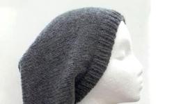 Dark gray hand knitted wool slouch hat. Suitable for men or women. It is made with a soft pure wool yarn. Completely hand knitted. Medium thickness, very stretchy, will fit any head, stretches out to 31 inches around. The measurements are lying flat on a