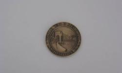 1.75" in diameter, one side has an inscription "World War II Memorial Washington, D.C." along the perimeter and a view of the memorial in the middle, the other side has an inscription "A Memorial to the Spirit, Sacrifice & Commitment of the American