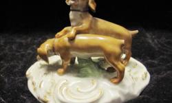 Meissen figurine of 2 dogs, 3 1/2" by 2 3/4". This figurine is probably circa 1930. The tail on one dog is repaired. The other tail is missing. One ear is chipped. The color and shape of this figurine are wonderful.