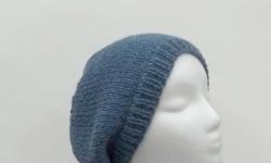 This hand knitted beanie slouch hat is medium denim blue. Made with a soft pure wool yarn. Medium thickness, very stretchy, will fit any head, stretches out to 31 inches around. The measurements are lying flat on a table, across the brim or ribbing = 9
