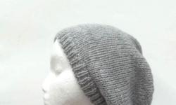 The color of this oversized beanie hat is a medium gray . Very stretchy, will fit any head, stretches out to 31 inches around. The measurements are lying flat on a table, across the brim or ribbing = 9 inches, across the widest part 11 1/2 inches and the