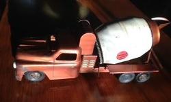 Selling this pressed-steel cement mixer truck made by Buddy L in the 1950s. It's about 22 inches long, about 7 inches wide. The truck frame is copper colored and the mixing barrel is white. It has a little rust and one small dent in the hood. It's never
