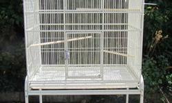 Large white birdcage, on stand with shelf, is in good, clean condition. Dimensions of the cage are 32 inches wide, 21 1/4 inches deep, 36 inches high. Total height with stand is 61 1/4 inches. Includes seed guard, several feeding dishes in different sizes