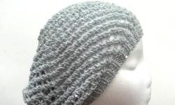 This open weave slouch beanie hat is the color light gray . A fun hat that will sparkle. Very airy and lightweight. The yarn has scattered small sequins that are the same color as the yarn. (see the close up photo). It is knitted with a soft acrylic yarn.