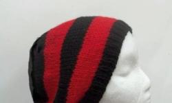 This knitted red black beanie is knitted with a soft wool and acrylic yarns. The stripes are red and black. This beanie is a medium thickness, very stretchy, will fit any head, will stretch out to 31 inches around. The measurements are lying flat on a