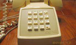 Retro corded phone with push buttons and classic ringtone. This is a beige AT & T 100 desk phone. It has some scratches and marks. It most likely works, but couldn't be tested since it probably needs a new connecting cord from the handset to the base. It