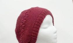 There are two rows of eyelets knitted into the hat. This wool knit beanie is a very pretty rose color. Will fit any head, stretches out to 31 inches around. This wool beret is made with a soft 100% pure new wool yarn The measurements are lying flat on a