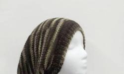 A wool slouch hat colors are variegated green, brown and tan colors. It is made with a variegated pure wool yarn. Medium thickness, very stretchy, will fit any head, stretches out to 31 inches around. The measurements are lying flat on a table, across the
